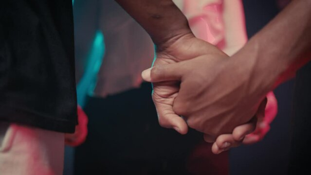 two black man and a white woman holding hands like praying 