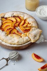 Biscuit with peaches on a stand sprinkled with powdered sugar and poured with honey..
