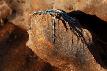 Blue rosary with a cross. Rosary prayer, rosary road, Rosary on stones, place for text. Catholicism