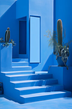 fachada azul de una casa mediterranea de lineas rectas con escaleras y plantas de cactus decorativas