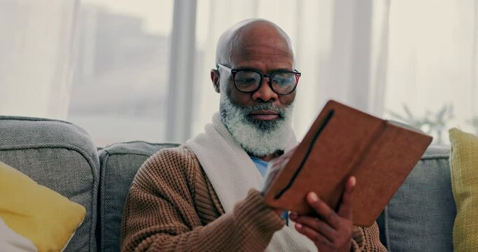 Home, notebook and senior man writing, planning or diary with ideas, inspiration or schedule for knowledge. Journal, writer or African person on couch with strategy, calm or to do list for creativity