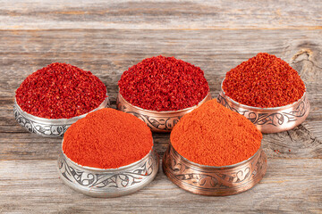 Hot chili pepper, sweet chili flakes and chili powder spice concept. Dry chili pepper flakes. Spices ingredients for cooking.
