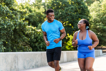 Portrait of authentic African American man and woman running together outdoors