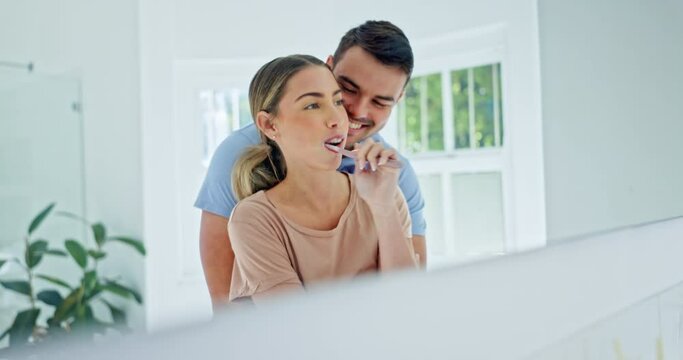 Mirror, love and couple hug while brushing teeth for dental, wellness and mouth cleaning routine in their home. Reflection, embrace and man with woman in a bathroom for teeth whitening or oral care