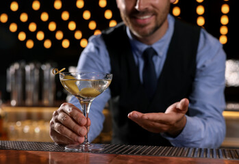 Bartender with fresh alcoholic cocktail in bar, closeup