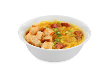 Bowl of delicious sauerkraut soup with smoked sausages, green onion and croutons isolated on white