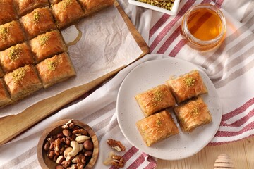 Delicious sweet baklava with nuts and honey on table, flat lay