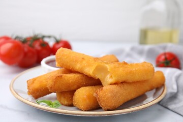 Tasty fried mozzarella sticks on white marble table