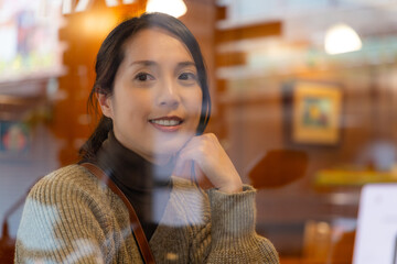 Woman look outside the window inside coffee shop