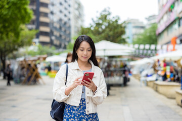 Woman use of mobile phone in city of Taipei