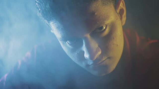Close-up shot of a confident killer in a red t-shirt prepping his next mission packing his fire arms and weapons. Cinematic full HD stock footage in ProRes.