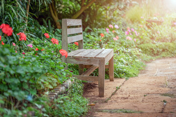 Fototapeta na wymiar Wood chair in autumn flowers garden background.