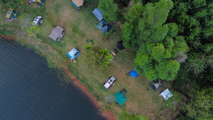 aerial view of camping by the river, tent in the forest.