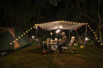 Outdoor camping tent with tarp or flysheet and Tent lighting, camping tent in the forest under night sky.