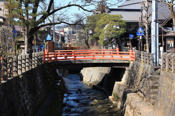 岐阜高山町の古い町並みを流れる川と赤い橋。