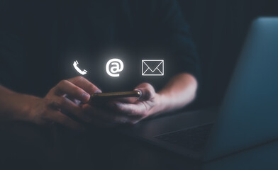 businessman using cell phone typing computer. working on laptop in concept of Contact us or Customer support hotline people connect. using smartphone to contact customer services