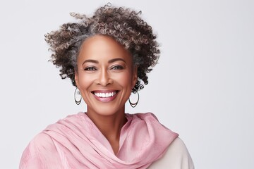 Close-up portrait of a happy plus size beautiful African American woman in her 50s. Middle-aged woman with a short gray hairdo looking at camera.