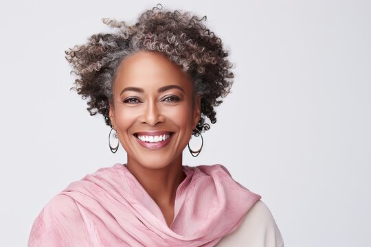 Close-up portrait of a happy plus size beautiful African American woman in her 50s. Middle-aged woman with a short gray hairdo looking at camera.