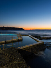 Obraz premium Dawn view of rock pool and rock formation at Curl Curl Beach, Sydney, Australia.