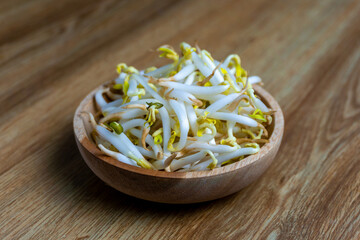 Beansprout in wooden bowl. Mungbean sprouts on wooden background.