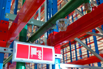 Fire sprinkler in a large warehouse with metal shelving
