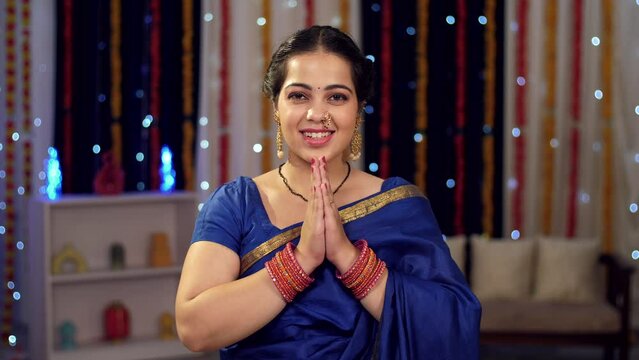 Beautiful Indian woman greeting with namaste gesture - Indian greeting  Diwali  Ganesh Chaturthi  Atithi Devo Bhava. Women dressed in beautiful blue sarees happily pose for the camera - Diwali fest...
