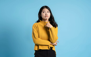 image of young asian girl posing on a blue background