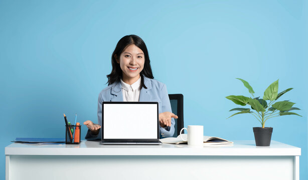 image of asian businesswoman sitting and using laptop on desk