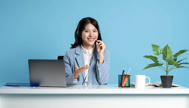 image of an asian consultant using a laptop on a blue background