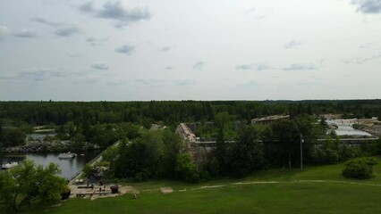 Aerial shot drone flies up and away from friends standing on dam at Pinawa Dam Provincial Heritage Park