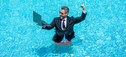 successful businessman man remote working online wth laptop in summer swimming pool on business vacation