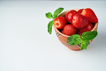 strawberries in a ceramic bowl on a light background