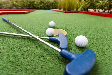 Golf stick and ball on green grass close up.