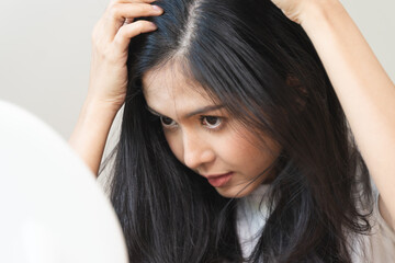 Fototapeta premium woman looking mirror to find hair problem