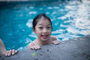 Asian girl with rubber ring at swimming pool