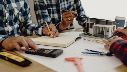 3rd male engineer designing house structure on table in office