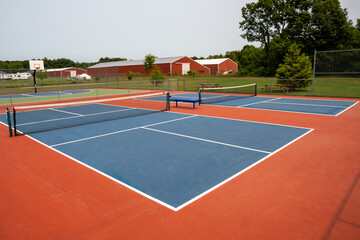 Recreational sport of pickleball court in Michigan, USA looking at an empty blue and orange clay...