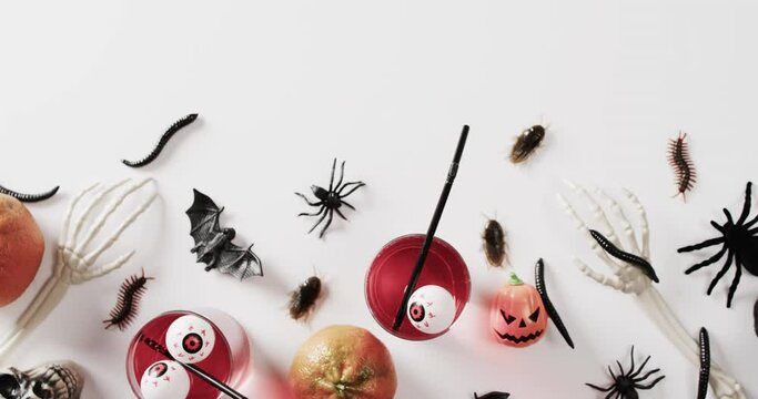 Video of halloween skeleton hands, drinks and decorations with copy space on white background