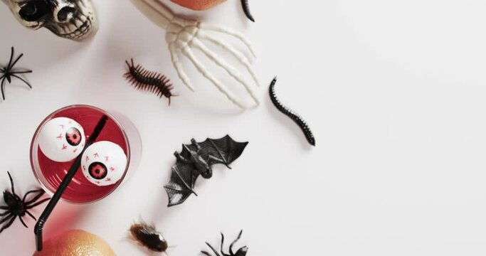 Video of halloween skeleton hands, drinks and decorations with copy space on white background