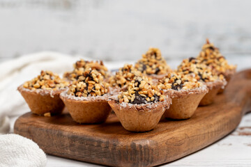 Tart cookies. Delicious mini tartlets with chocolate cream and nuts on a white background