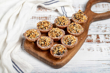 Tart cookies. Delicious mini tartlets with chocolate cream and nuts on a white background