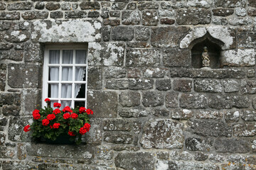 Fototapeta na wymiar Windows and wall of a traditional breton cottage - Medieval village of Locronan - Finistere - Brittany - France