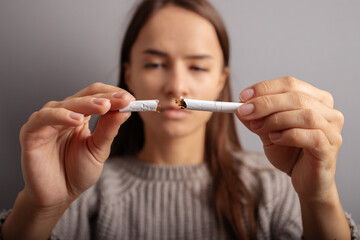 Obraz premium teenager breaks a cigarette, rejection of tobacco, stop smoking