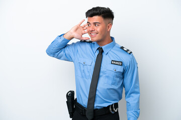 Young police caucasian man isolated on white background listening to something by putting hand on the ear
