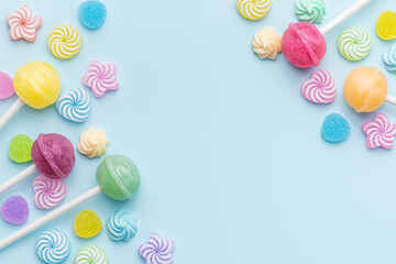 Fototapeta na wymiar Sweet lollipops and candies on blue background