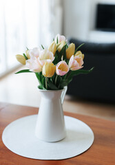 Spring tulips in a vase on the table. Spring holiday, home decor.