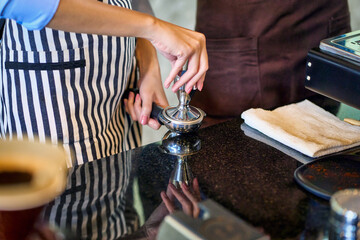 Barista pressing espresso with tamper in coffee machine , coffee cafe shop concept.