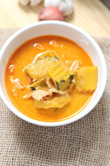 Red Curry Pumpkin with Chicken served on wooden table, delicious Thai food popular in Thailand, Asia food.