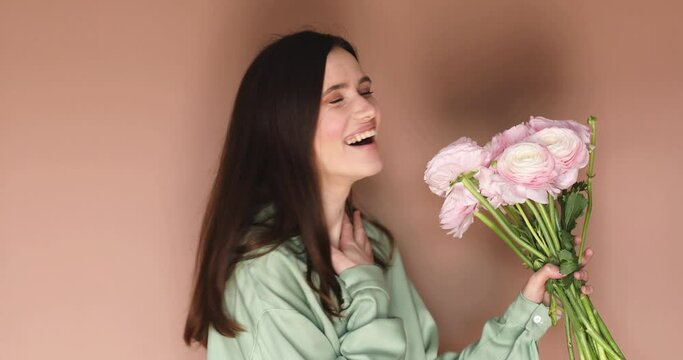 Woman non expected have a bouquet of ranunculus flowers, she turn and surprised when man hand give to her a flowers. Man giving a bouquet of flowers and surprised. Wow emotions.
