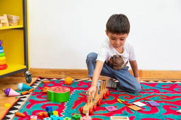 Boy playing with wooden train toy in kindergarten
